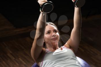 Young Woman Doing Heavy Weight Exercise For Chest