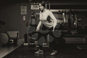Young Woman Doing Heavy Weight Exercise For Back