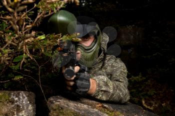 Paintball Players Hide Behind Tree