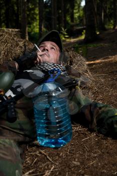 Paintball player resting and smoking a cigar