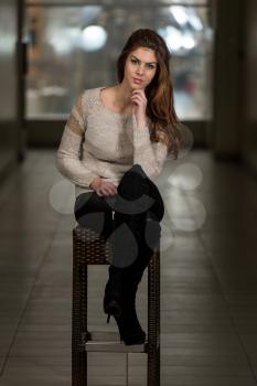 Beautiful Young Brown Model Sitting On The Chair