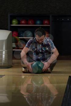 Cheerful Young Man Holding Bowling Ball