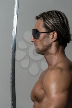 Portrait Of A Handsome Muscular Ancient Warrior With A Sword