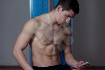 Young Man Texting While Fitness Sesion