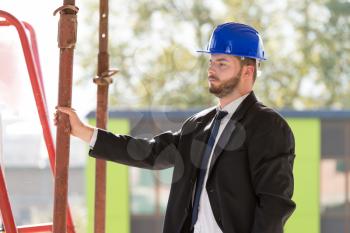 Portrait Of Business Man With Blue Helmet On Construction