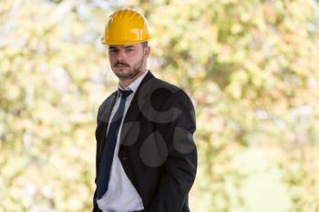 Portrait Of Business Man With Yellow Helmet On Construction