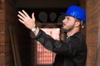 Young Construction Pointing On Ceiling