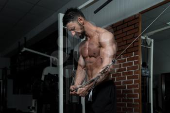 Bodybuilder Is Working On His Chest With Cable Crossover In A Dark Gym
