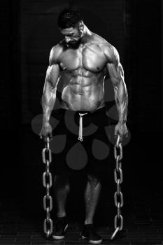 Portrait Of A Physically Fit Man Showing His Well Trained Body And Holding Chains