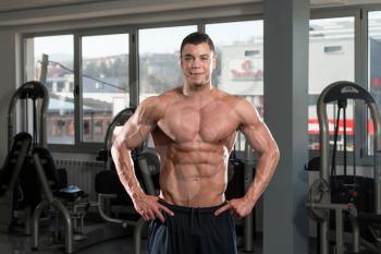 Portrait Of A Physically Fit Man Showing His Well Trained Body In Gym