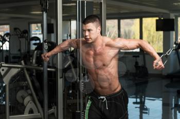 Young Bodybuilder Is Working On His Chest With Cable Crossover In A Dark Gym