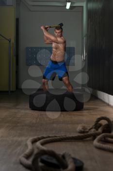 Athletic Man Hits Tire - Workout At Gym With Hammer And Tractor Tire