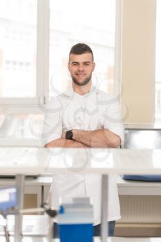Portrait Of A Caucasian Student In A Chemistry Lab Smiling And Looking In The Camera With Hands Folded