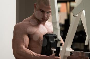 Male Bodybuilder Doing Heavy Weight Exercise For Back In Gym