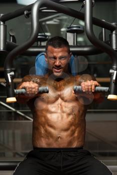 Adult Bodybuilder Doing Heavy Weight Exercise For Chest On Machine