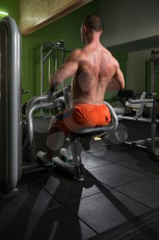 Young Bodybuilder Doing Heavy Weight Exercise For Back On Machine