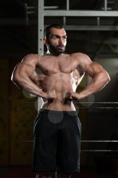 Portrait Of A Young Fit Man Performing Front Lat Spread Pose - Muscular Athletic Bodybuilder Fitness Model Posing After Exercises