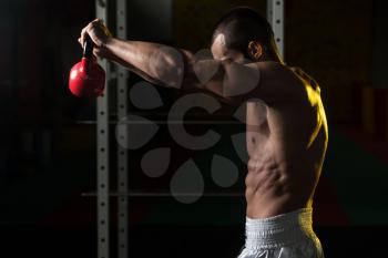 Young Man Working With Kettle Bell In Gym