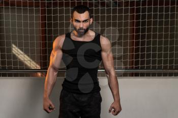Portrait Of A Young Fit Man Showing His Well Trained Body In Tank - Muscular Athletic Bodybuilder Fitness Model Posing After Exercises