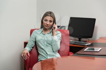 Successful Businesswoman Or Entrepreneur Talking On Cellphone While Working Indoors - City Business Woman Working