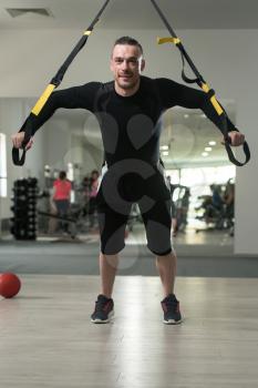 Attractive Man Does Crossfit With Trx Fitness Straps In The Gym's Studio