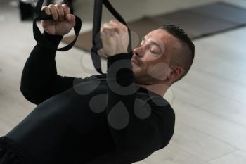 Attractive Man Does Crossfit Push Ups With Trx Fitness Straps In The Gym's Studio