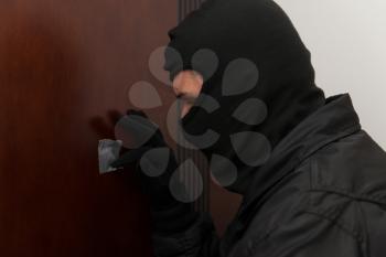 Burglar Breaks Into A Residential Building And Thief In The Mask Covers Peep Hole