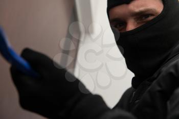 Man With A Black Mask Is Breaking Into A Home