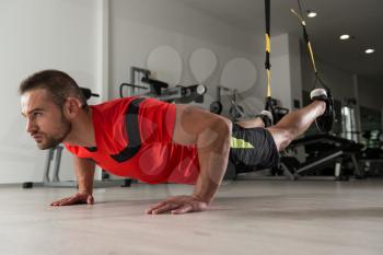 Fitness Instructor Exercising Crossfit With Trx Fitness Straps In The Gym's Studio