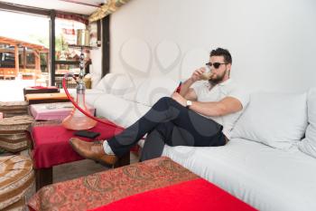 Man Smoking Turkish Hookah In The Cafe With Colorful Walls On Background