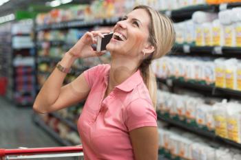 Young Woman Shopping in Supermarket While Using Smartphone in Store