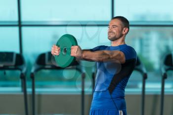 Young Fitness Man Working Out Shoulders In Fitness Center With Weights