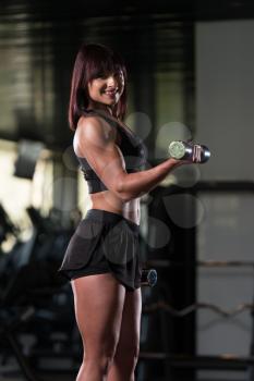 Young Woman Working Out Biceps In A Gym - Dumbbell Concentration Curls