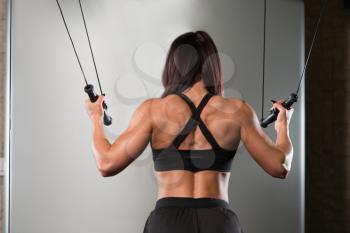 Young Woman Is Working On Her Back With Cable Crossover In A Modern Fitness Gym