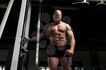 Muscular Fitness Bodybuilder Doing Heavy Weight Exercise For Shoulders On Cable Machine In The Gym