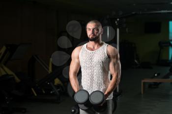 Man Working Out Shoulders In A Gym - Dumbbell Concentration Curls