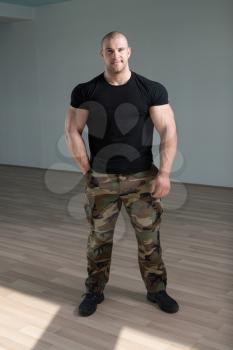 Portrait Of A Young Physically Fit Man Showing His Well Trained Body In Army Pants - Muscular Athletic Bodybuilder Fitness Model Posing After Exercises