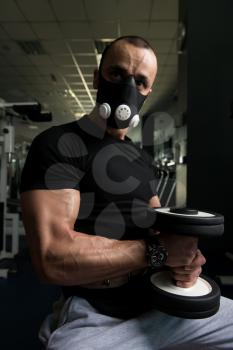 Athlete Working Out Biceps In Elevation Mask - Dumbbell Concentration Curls