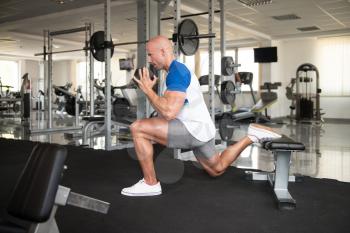 Strong Man In The Gym Exercising Legs With Dumbbells - Muscular Athletic Bodybuilder Fitness Model Exercise