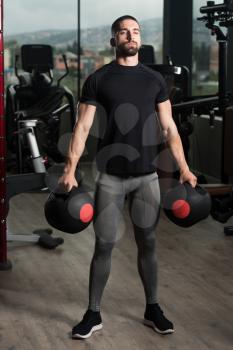 Portrait Of A Physically Young Man Holding Weights In Medicine Balls