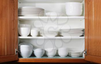 Whites dishes and bowls in oak cabinet kitchen shelf