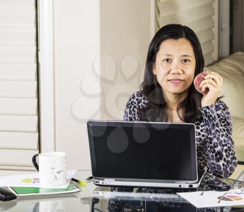 Mature women having snack while at work in home office