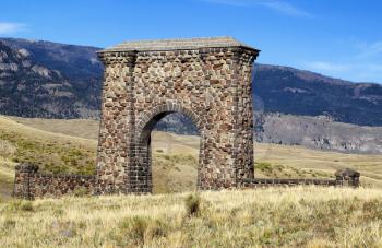 Closeup horizontal image of Yellowstone National Park Roosevelt Stone Arch at the North entrance in Montana with blue skies and clouds 