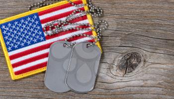 American flag and dog tags on rustic wood background