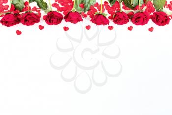 Red roses and heart shapes forming upper border on white background
