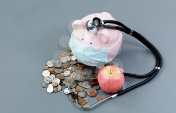 health of the economy with piggybank and medical equipment 
