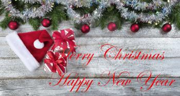 Merry Christmas or Happy New Year holiday background with gifts and other decorations plus written text message 