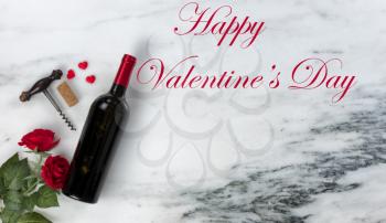 Happy Valentines Day with lovely red rose flowers and red wine with heart shapes on natural marble stone background plus text message