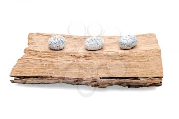 Three stones on a grunge wood isolated on white