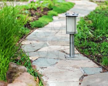 Solar-powered lamp on garden background. Selective focus.